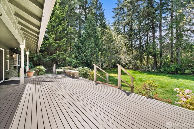wooden deck featuring a lawn