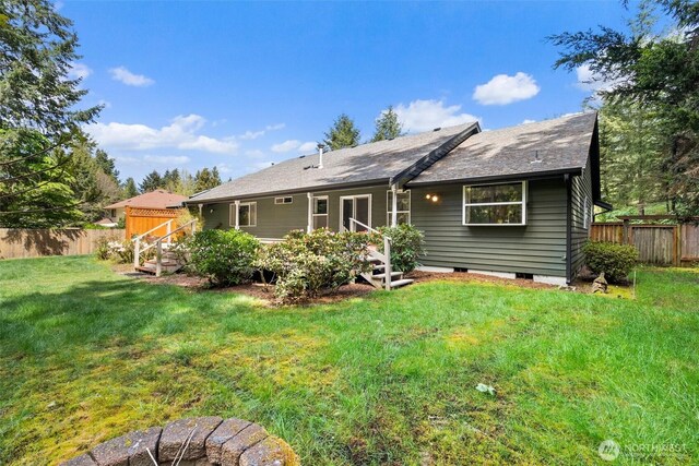 back of property with a yard and fence
