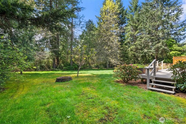view of yard featuring a wooden deck and an outdoor fire pit