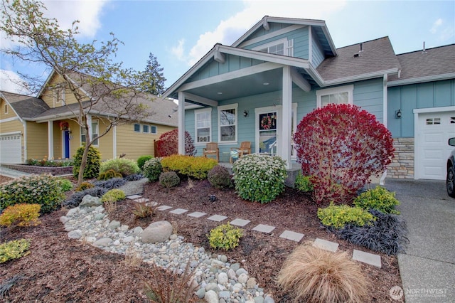 454 S 48th St, Mount Vernon, WA 98274 - view of front of home featuring a garage, a shingled roof, board and batten siding, and covered porch
