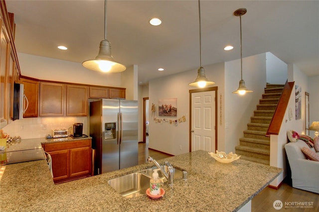 454 S 48th St, Mount Vernon, WA 98274 - kitchen with decorative backsplash, light stone countertops, brown cabinets, a sink, and appliances with stainless steel finishes