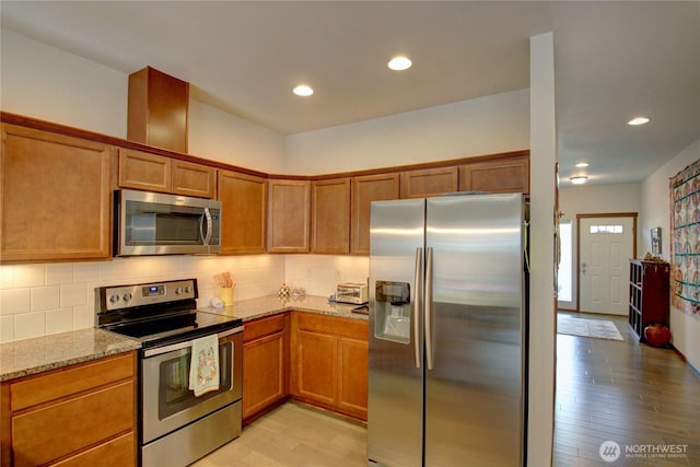 454 S 48th St, Mount Vernon, WA 98274 - kitchen featuring brown cabinets, stainless steel appliances, light stone counters, and light wood finished floors
