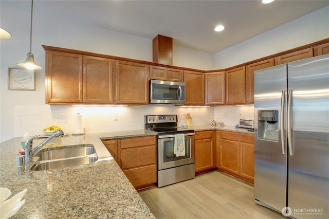 454 S 48th St, Mount Vernon, WA 98274 - kitchen with decorative backsplash, appliances with stainless steel finishes, a sink, light stone counters, and light wood-style flooring