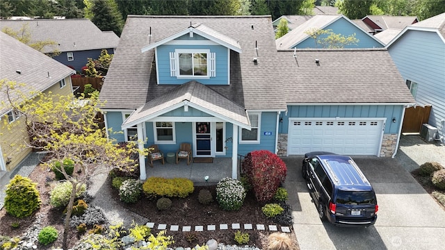 454 S 48th St, Mount Vernon, WA 98274 - view of front facade featuring roof with shingles, concrete driveway, a porch, and stone siding