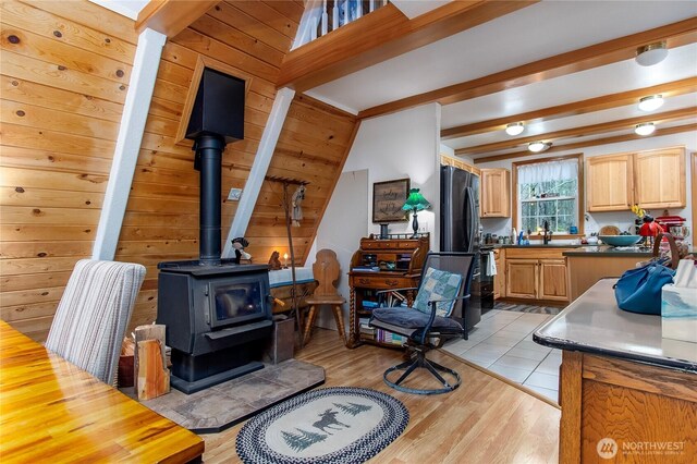 121 Sunstone Rd, Packwood, WA 98361 - interior space with beam ceiling, a wood stove, and light wood-type flooring