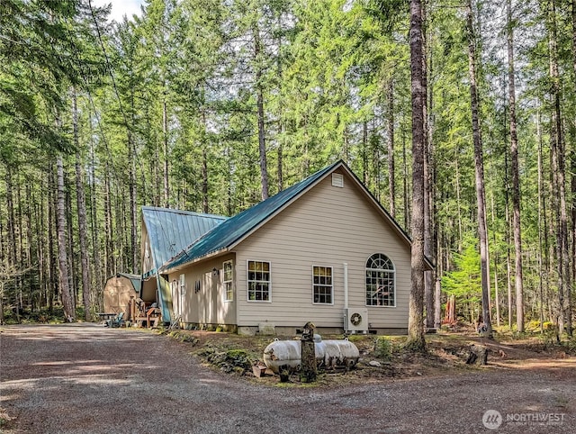 121 Sunstone Rd, Packwood, WA 98361 - view of home's exterior featuring ac unit, a view of trees, aphalt driveway, and metal roof