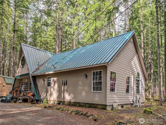 121 Sunstone Rd, Packwood, WA 98361 - view of property exterior featuring a view of trees, ac unit, and metal roof