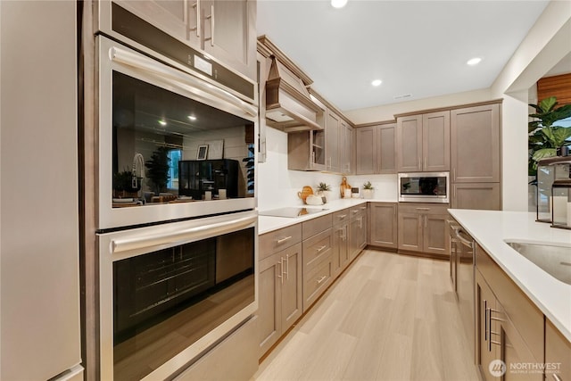 kitchen featuring light wood-style floors, light countertops, stainless steel appliances, recessed lighting, and custom range hood
