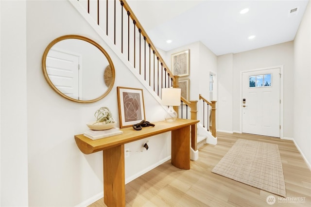 foyer with recessed lighting, light wood-style flooring, baseboards, and stairway