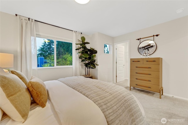 carpeted bedroom featuring baseboards and multiple windows