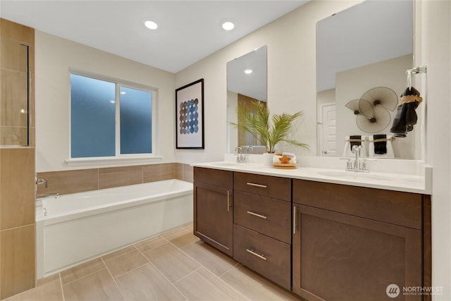 bathroom featuring double vanity, a sink, and a bath