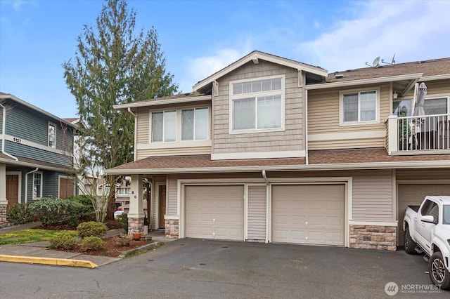 townhome / multi-family property with a garage, aphalt driveway, stone siding, and a shingled roof