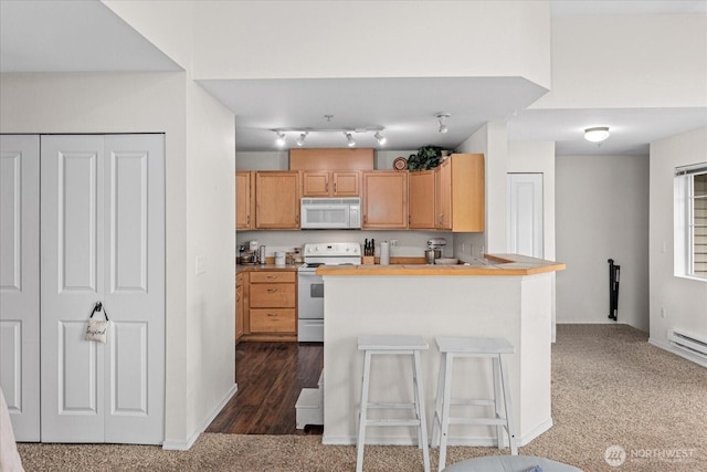 kitchen with a breakfast bar area, baseboards, a peninsula, dark colored carpet, and white appliances