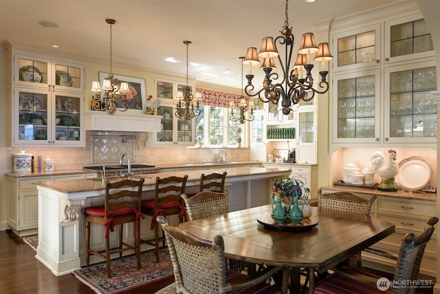 dining space with dark wood-style flooring, recessed lighting, an inviting chandelier, and crown molding