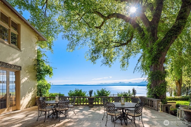 view of patio with outdoor dining area and a water view