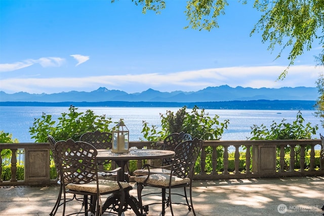 view of patio featuring a water and mountain view and outdoor dining space
