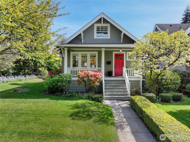 view of front of home with covered porch and a front lawn