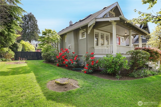 view of home's exterior with a porch, fence, and a yard