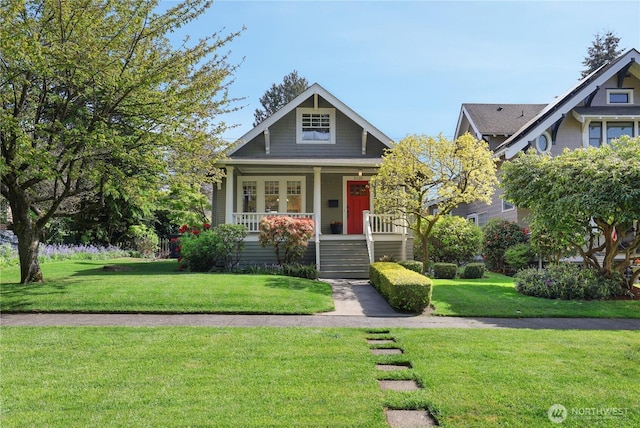craftsman-style house with covered porch, stairs, and a front yard