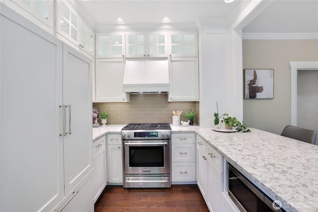 kitchen with appliances with stainless steel finishes, ornamental molding, and white cabinetry