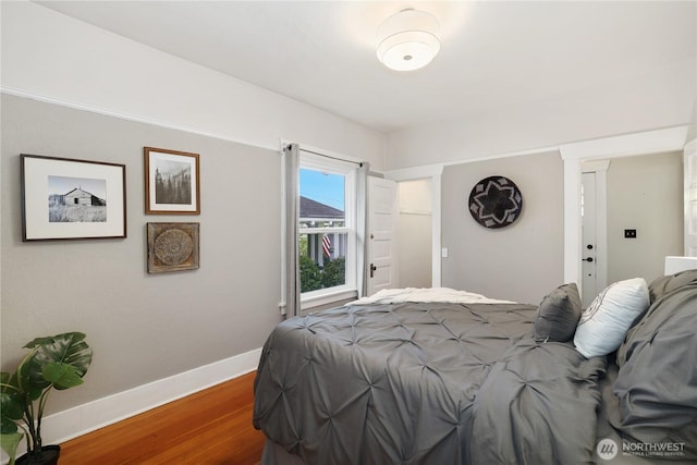 bedroom with baseboards and wood finished floors