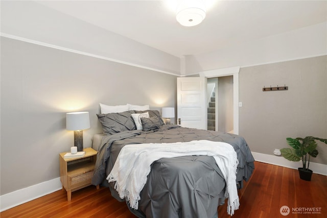 bedroom featuring baseboards and wood finished floors