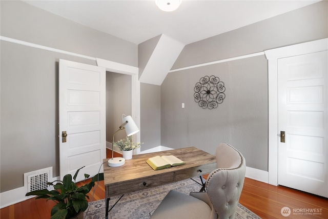 office featuring baseboards, visible vents, and wood finished floors