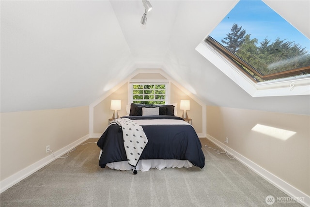 carpeted bedroom featuring baseboards and lofted ceiling with skylight