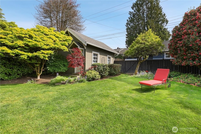 view of yard with fence and an outbuilding