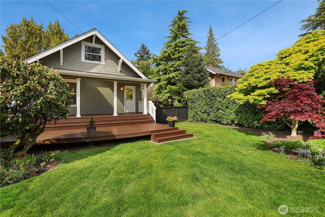 rear view of house with a lawn and fence