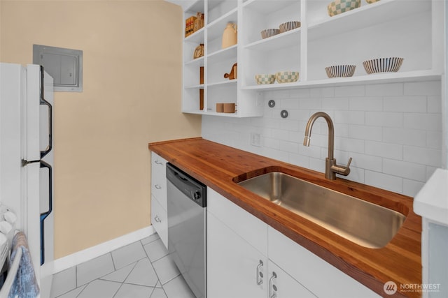 kitchen featuring stainless steel dishwasher, a sink, wood counters, backsplash, and white cabinets