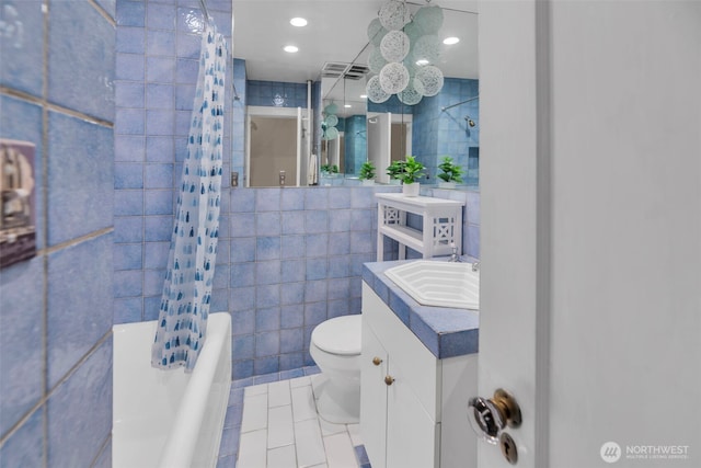 full bath with tile walls, toilet, tile patterned flooring, vanity, and shower / tub combo with curtain