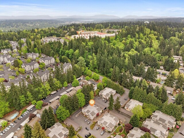 drone / aerial view featuring a mountain view and a forest view