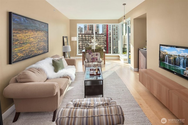 living area with baseboards and light wood-style flooring