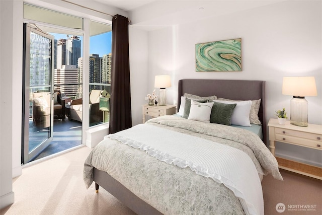 carpeted bedroom featuring access to outside and a city view