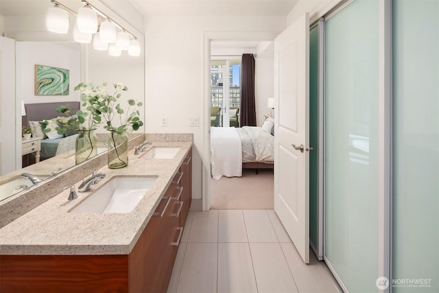 ensuite bathroom featuring a sink, tile patterned flooring, ensuite bath, and double vanity