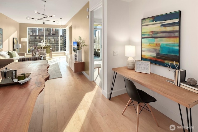 office featuring a wealth of natural light, light wood-style flooring, and a notable chandelier