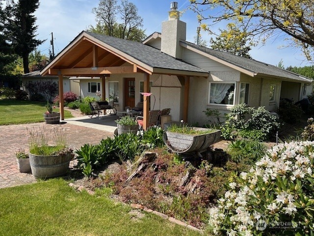 1557 Shelton Rd, Walla Walla, WA 99362 - back of property with a patio area, a chimney, a yard, and roof with shingles