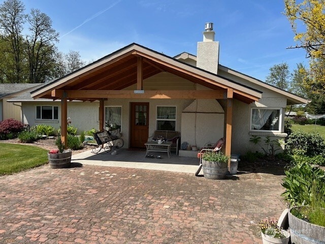 1557 Shelton Rd, Walla Walla, WA 99362 - back of property featuring a chimney, a patio, and stucco siding