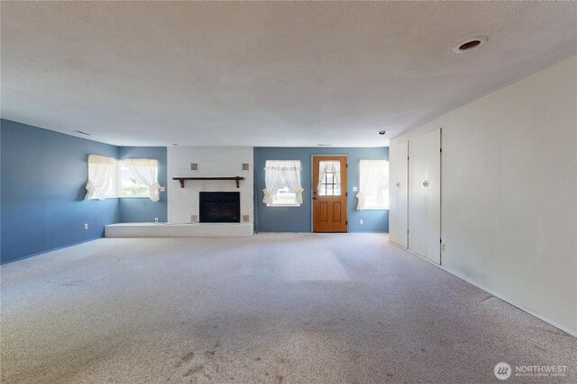 1557 Shelton Rd, Walla Walla, WA 99362 - unfurnished living room featuring a fireplace, carpet flooring, plenty of natural light, and baseboards
