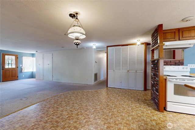1557 Shelton Rd, Walla Walla, WA 99362 - kitchen with electric range, hanging light fixtures, brown cabinetry, and open floor plan
