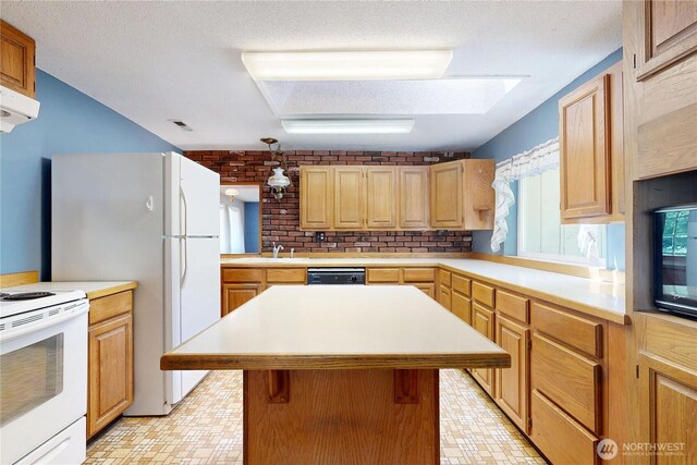 1557 Shelton Rd, Walla Walla, WA 99362 - kitchen featuring white appliances, a sink, light countertops, a center island, and a skylight