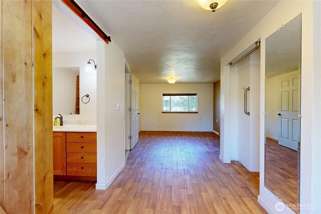 1557 Shelton Rd, Walla Walla, WA 99362 - corridor with light wood-type flooring, baseboards, and a sink