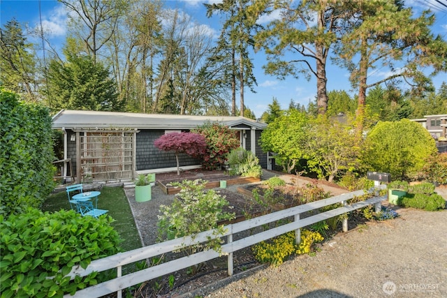 view of front of house with a garden and fence