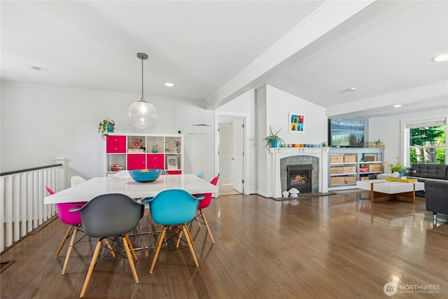 dining space featuring a fireplace, recessed lighting, and wood finished floors
