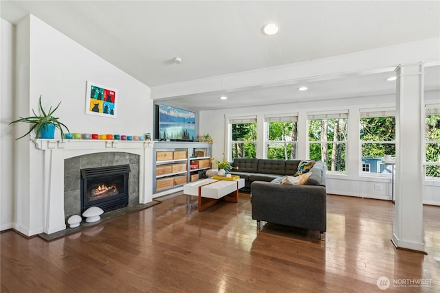 living room featuring recessed lighting, wood finished floors, lofted ceiling, and a fireplace