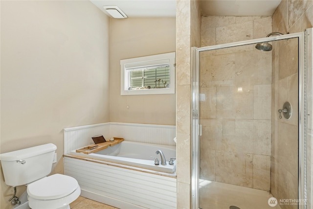 bathroom featuring tile patterned floors, a stall shower, toilet, and a bath
