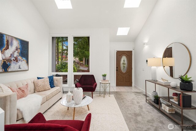 living area featuring baseboards, carpet flooring, and lofted ceiling with skylight