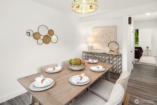 dining space featuring baseboards and wood finished floors
