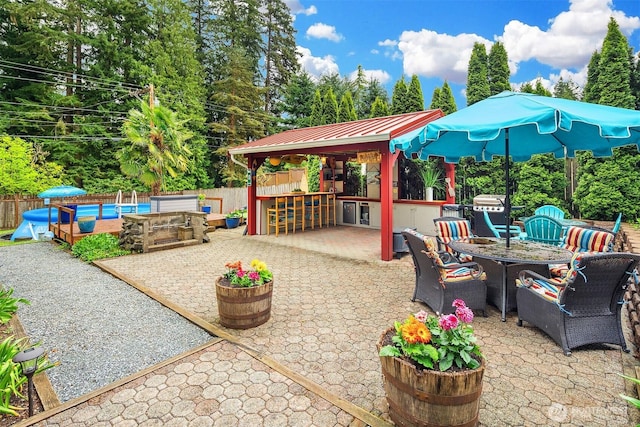 view of patio with fence, outdoor dry bar, and outdoor dining space